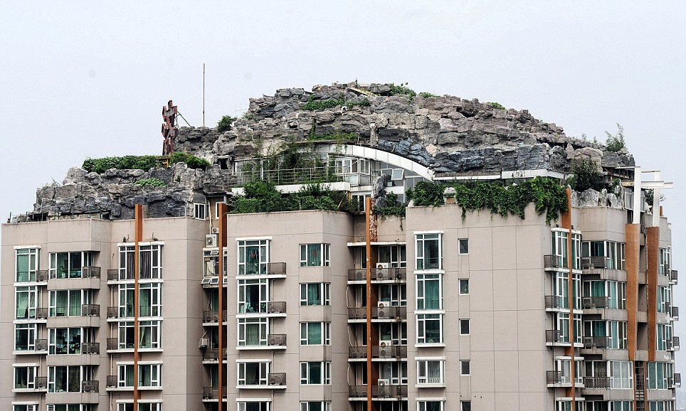 صيني يبني هضبة صخرية وفوقها فيلا على سطح عمارة